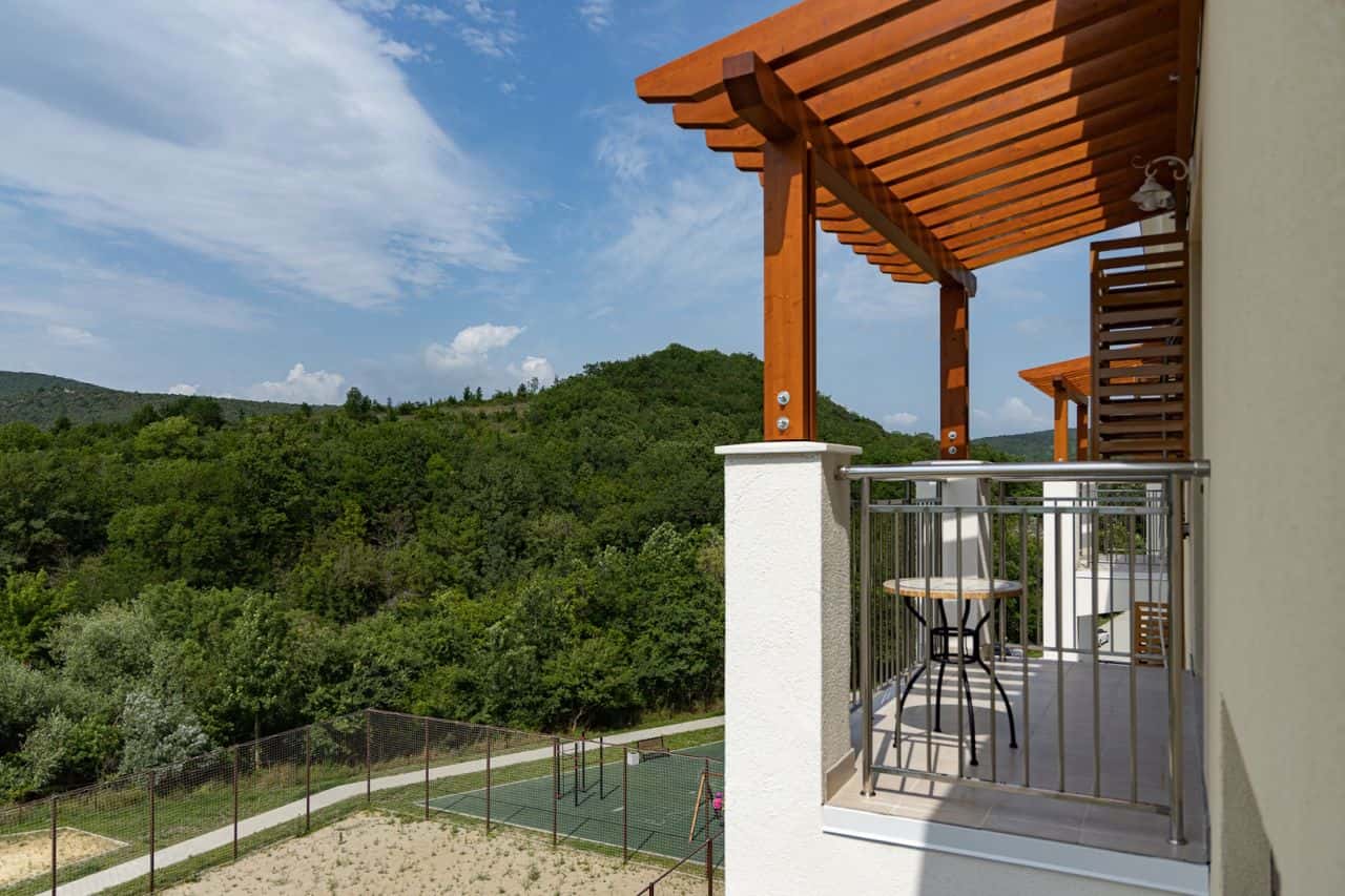 Балкон квартиры Holiday HOUSE с видом на лесистые холмы Сукко